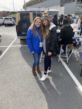 Jamie Garity and her daughter Amara smile for a picture at a WVU tailgate.