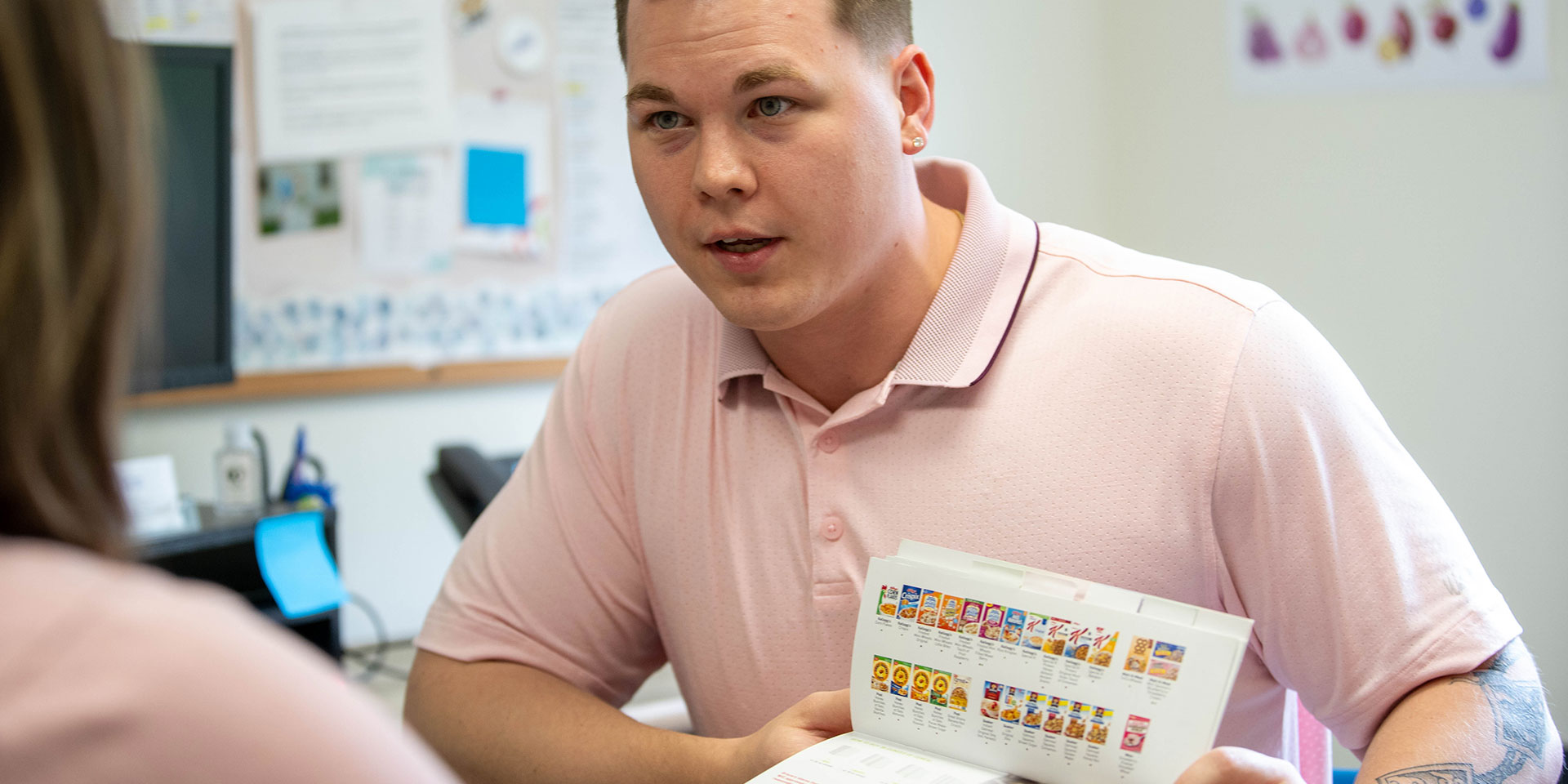 Austin is speaking with a client illustrating a brochure in the process.