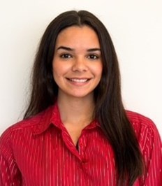 Smiling female with long dark hair wearing a red button down top.